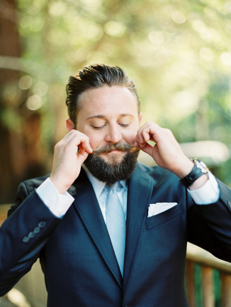 Groom curling his mustache at his organic inspired wedding at the Outdoor Art Club in Mill Valley, California. www.kaylayestal.com